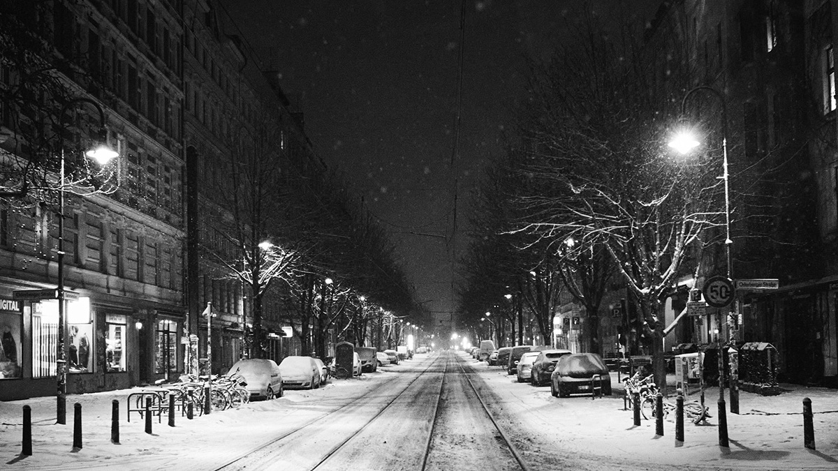 Schwarz-Weiß-Bild einer verschneiten Straße in Berlin.