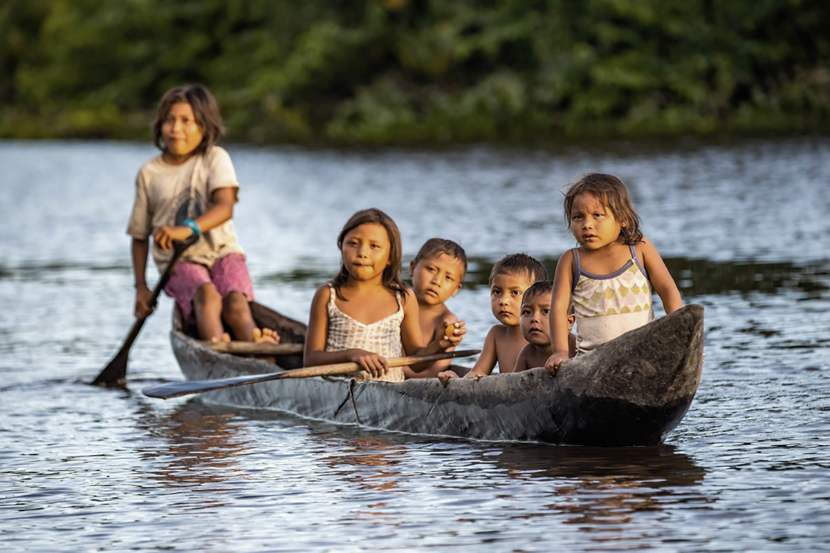 Kinder in einem traditionellen Holzboot auf dem Orinoco in Venezuela. 