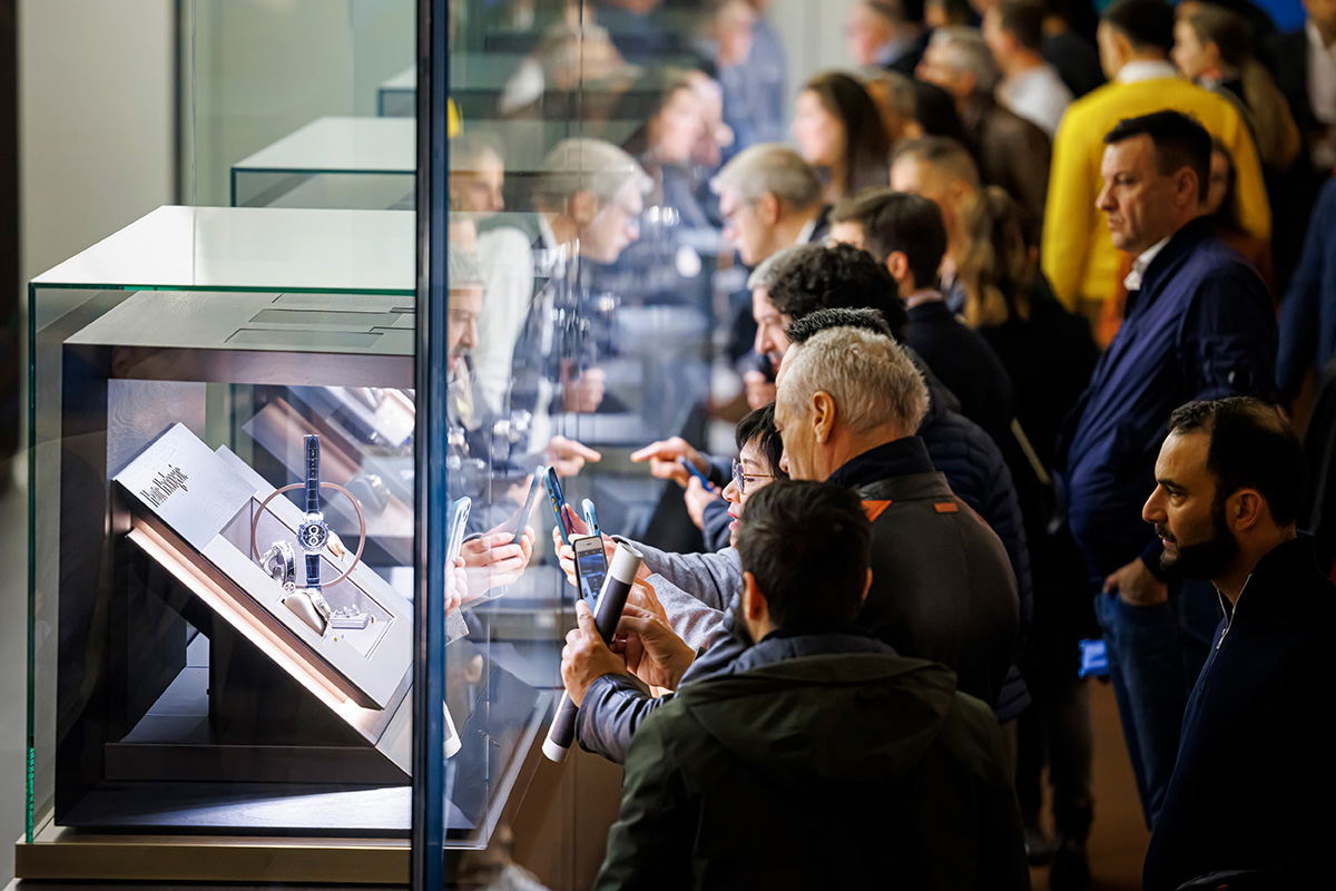 Besucher schauen auf der Uhren-Messe „Watches and Wonders” in Genf auf eine Vitrine.