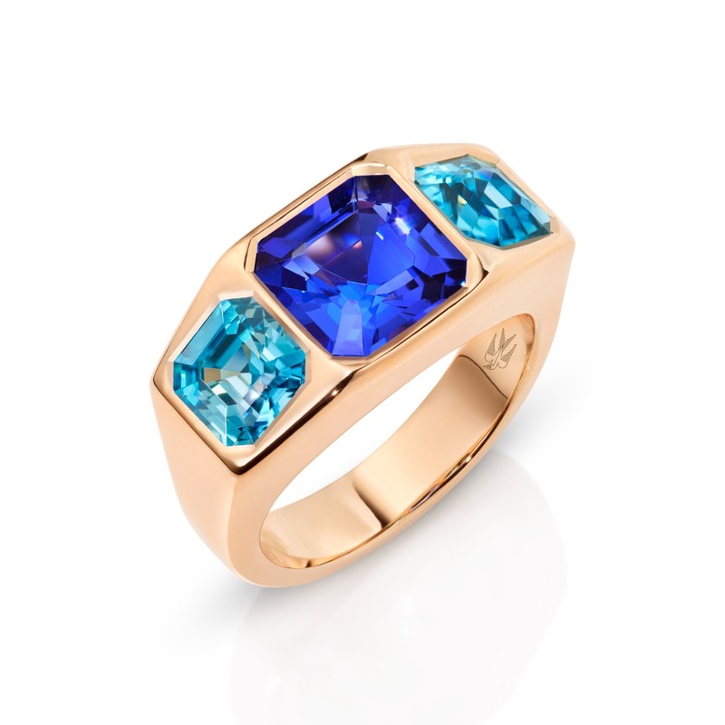 Goldring in Roségold mit einem großen blauen Tansanit in der Mitte und zwei rechteckigen Zirkonen links und rechts.