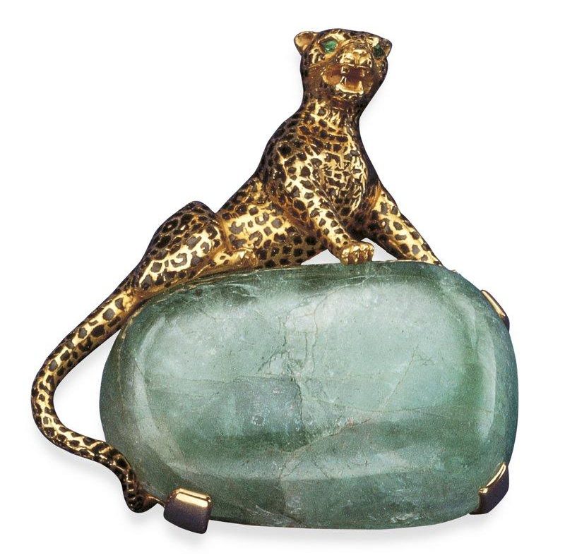 Brosche von Cartier aus dem Jahr 1948: plastischer goldener Panther mit schwarzen Onyx-Flecken sitzt auf einem großen, rechteckigen Smaragd-Cabochon; gefertigt für die Herzogin von Windsor.