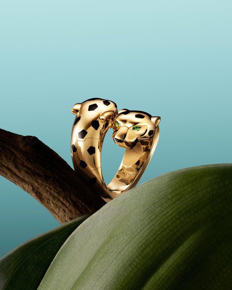Ring aus Gelbgold mit zwei gegenüber liegenden Pantherköpfen; Oberfläche mit grafischen schwarzen Lack-Flecken; Panthère de Cartier Kollektion 2025.