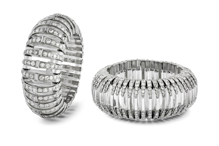 BT27A30-v_BT28A30_fb_SG Zwei breite Art-Déco-Armreifen von Cartier, mit Brillanten und Baguette-Diamanten besetzt; ein Armreif steht aufrecht, der andere liegt flach, freigestellt auf weißem Hintergrund.
