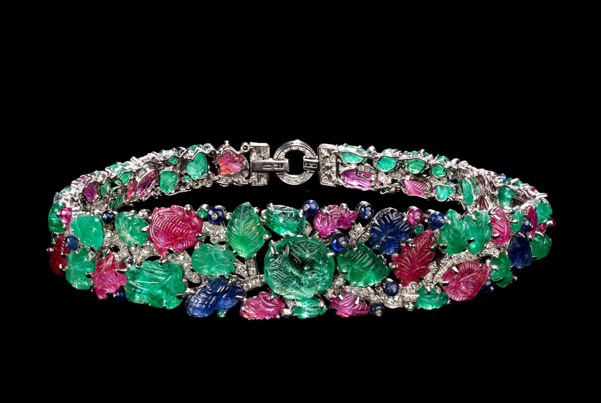 substantial-times-cartier-im-victoria-and-albert-museum-glanz-macht-und-mythos-mountbatten-bandeau-05 Mountbatten-Bandeau im Tutti-Frutti-Stil (Cartier London, 1928): gravierte Smaragde, Rubine und Saphire mit Diamanten in Platin; frontal freigestellt vor schwarzem Hintergrund.