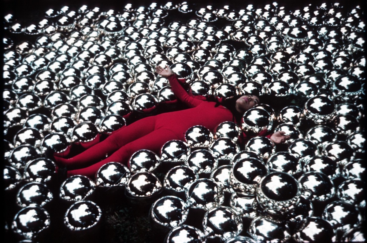 substantial-times-yayoi-kusama-nichts-hat-ein-ende-05 Yayoi Kusama im roten Bodysuit liegend zwischen hunderten spiegelnder Metallkugeln in der Installation Narcissus Garden (1966).