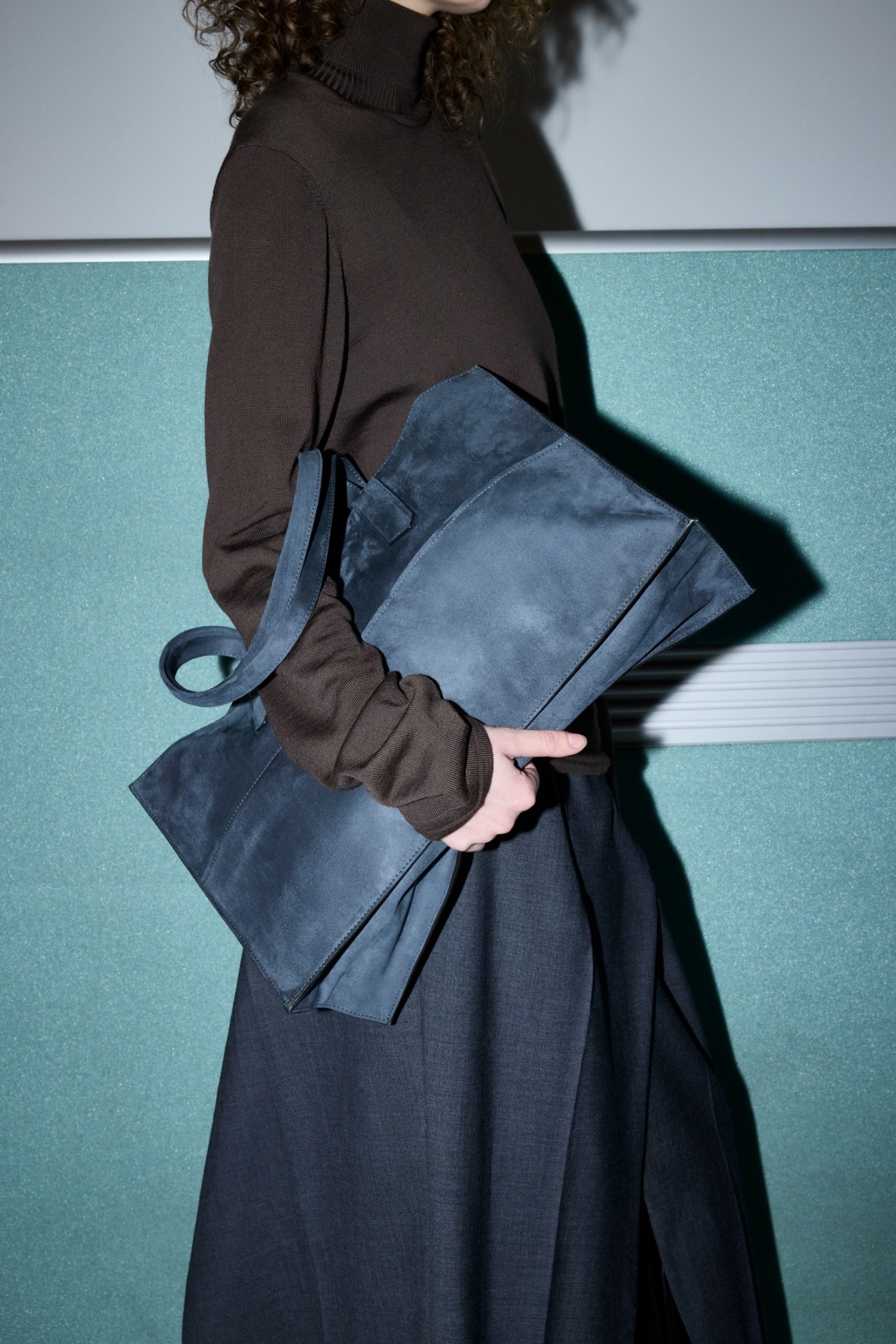 Keramikvasen und Porzellanblüten von Coco Loves Clay: eine kugelförmige und eine zylindrische weiße Vase mit strukturierter Oberfläche, dazu unglasierte Blüten und Zweige, arrangiert auf dunklem Untergrund mit weihnachtlichen Motiven.