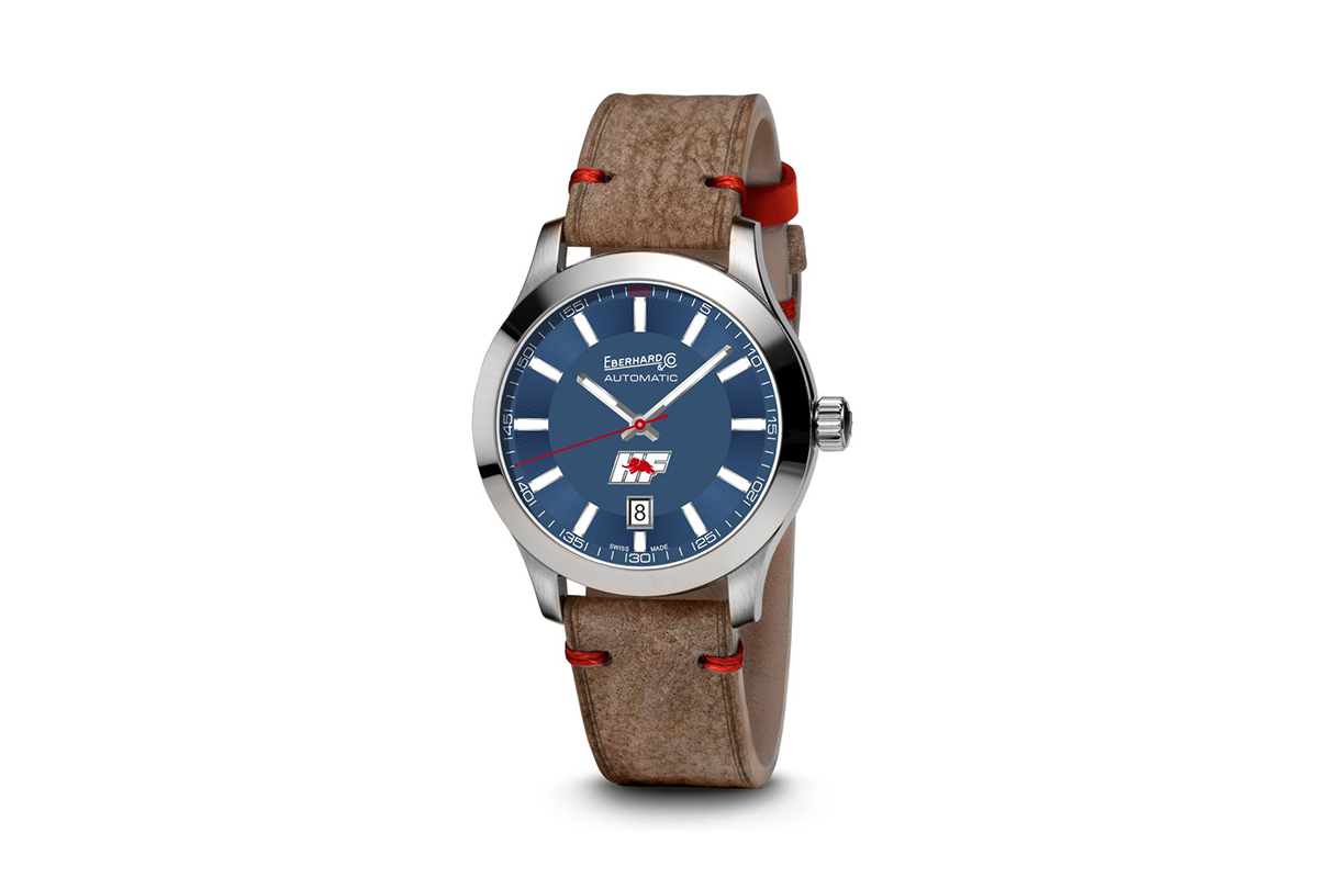 Schachtel mit getrockneten Bio-Lavendelblüten in kleinen Baumwollsäckchen, dazu ein gebündelter Lavendelstrauß, arrangiert auf violettem Stoff.