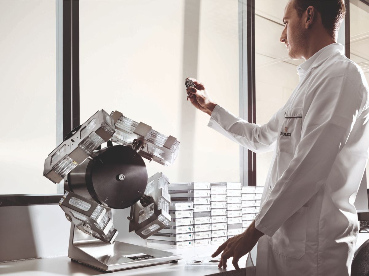Ein Uhrmacher überprüft die chronometrische Präzision und Leistungswerte eines Rolex Uhrwerks an einem Prüfgerät.