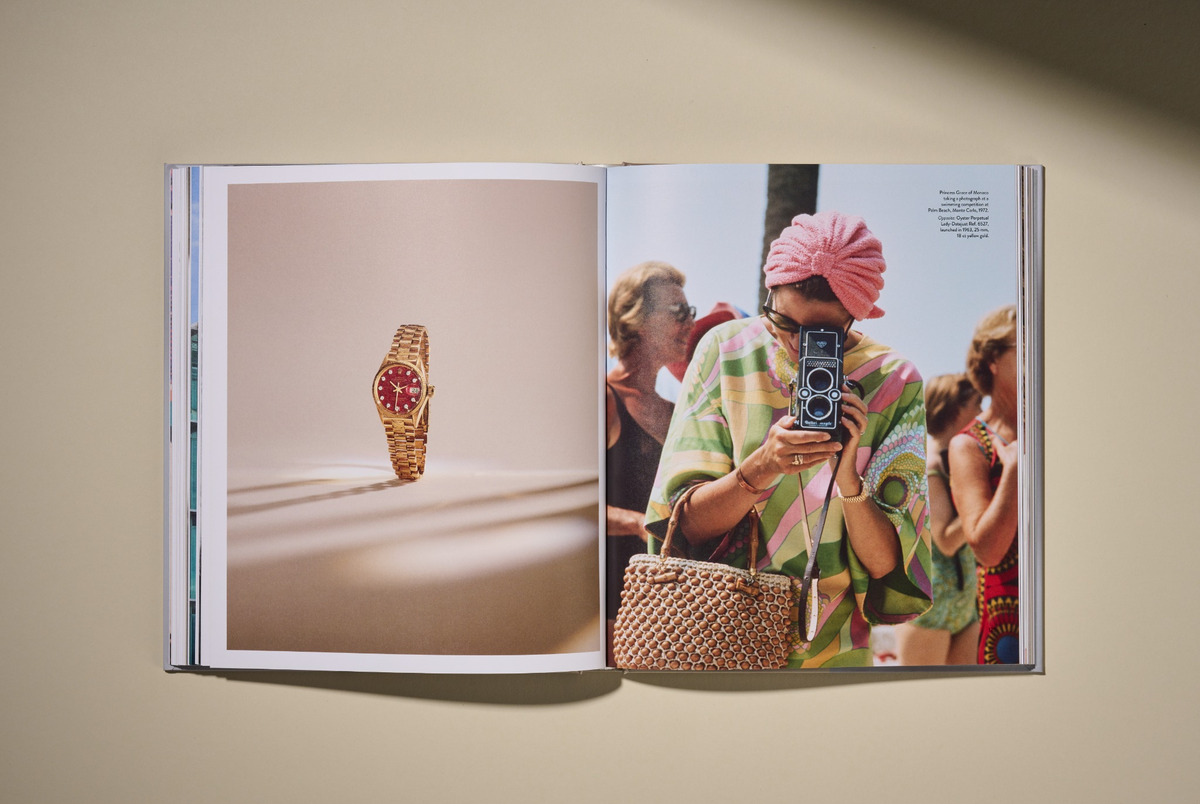Aufgeschlagenes Buch mit Doppelseite: links eine freigestellte goldene Rolex Lady-Datejust mit rotem Zifferblatt, rechts ein historisches Foto von Fürstin Grace von Monaco, die 1972 bei einem Schwimmwettbewerb am Palm Beach, Monte Carlo, eine Kamera hält. Sie trägt einen rosafarbenen Frotteeturban und ein Kleid von Pucci.