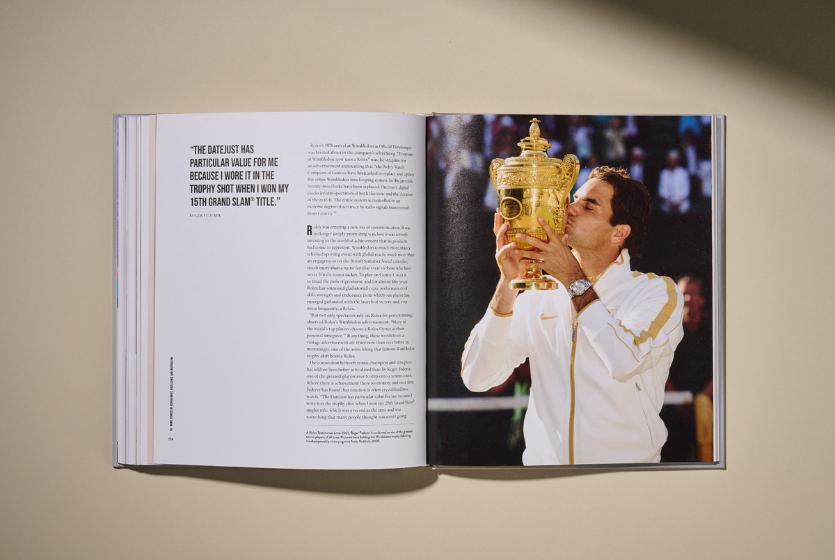 Aufgeschlagenes Buch mit Doppelseite: links ein groß gesetztes Zitat von Roger Federer zur Rolex Datejust, rechts ein Foto von Federer, der 2009 nach seinem Wimbledon-Sieg den Siegerpokal hält und küsst.