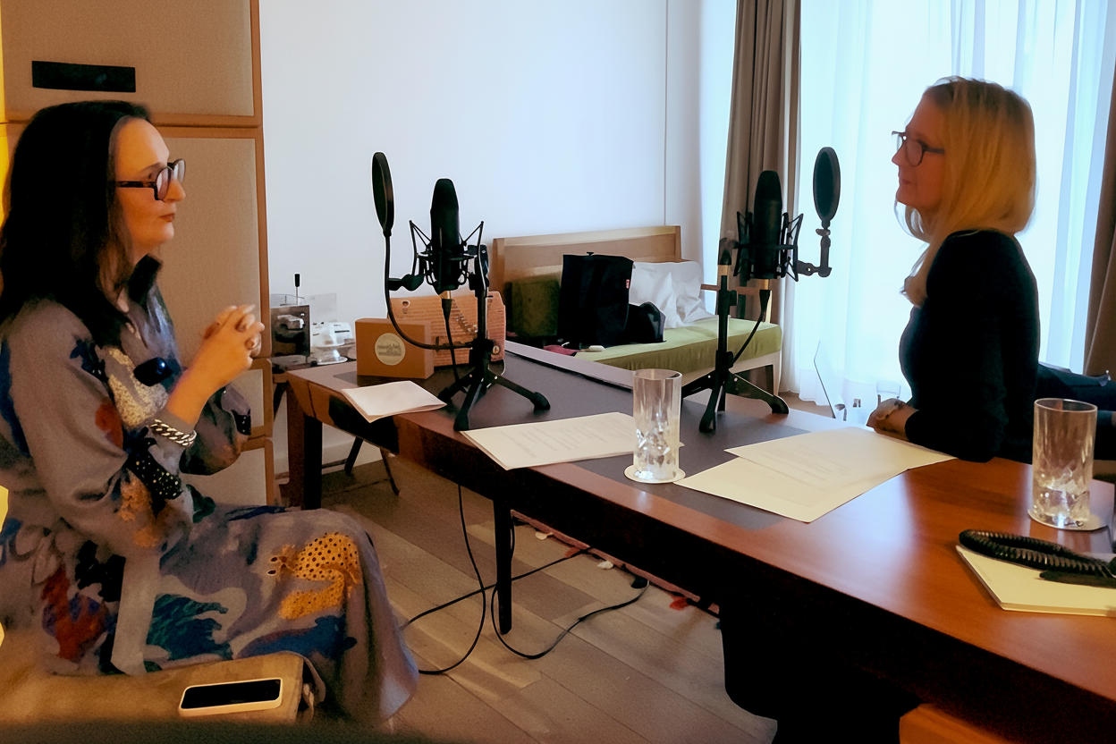 Hotelzimmer mit zwei Mikrofonen auf einem schmalen Tisch, links sitzt Bettina Schrenk, rechts Substantial-Times-Chefredakteurin Elke Reinhold.