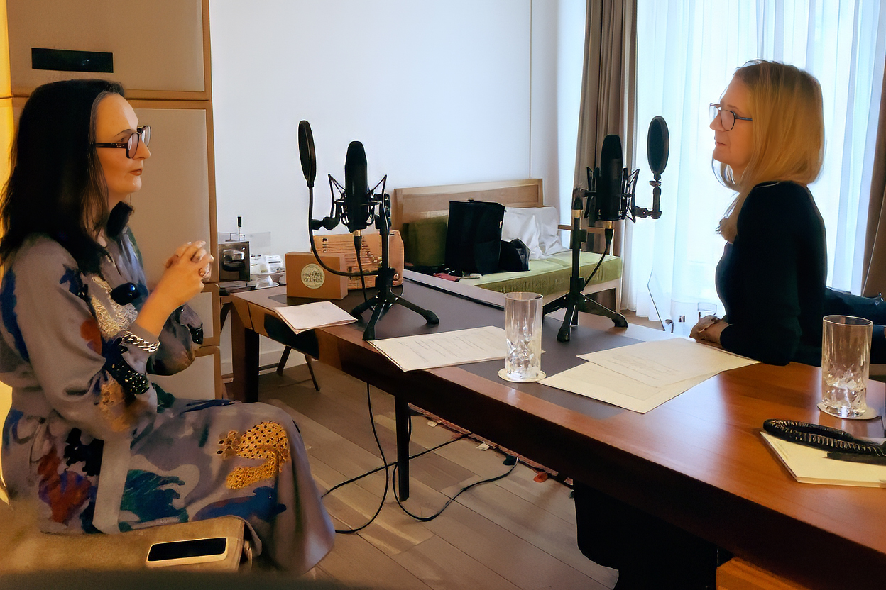 Hotelzimmer mit zwei Mikrofonen auf einem schmalen Tisch, links sitzt Bettina Schrenk, rechts Substantial-Times-Chefredakteurin Elke Reinhold.