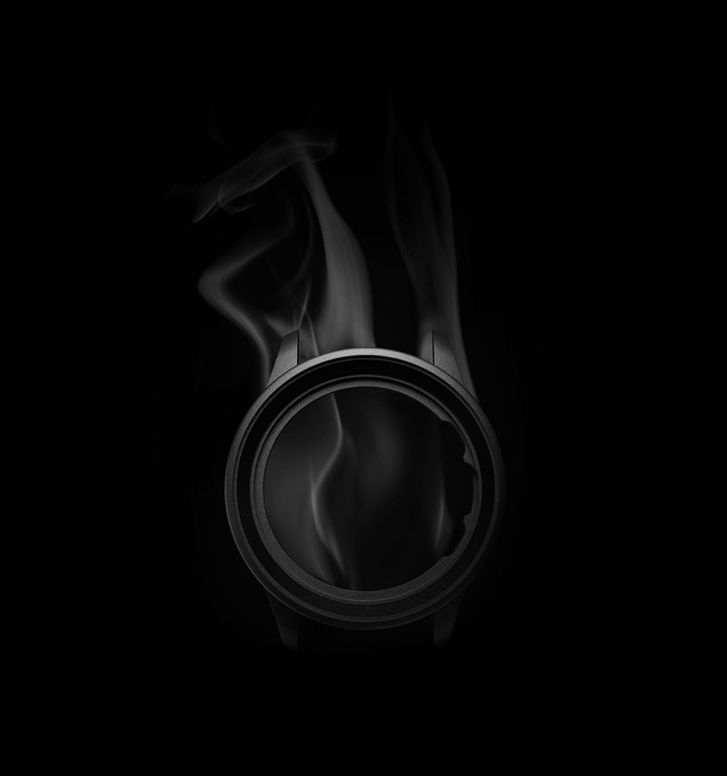 Gehäuse der IWC Portugieser Chronograph aus schwarzem Ceratanium mit aufsteigendem Rauch vor dunklem Hintergrund