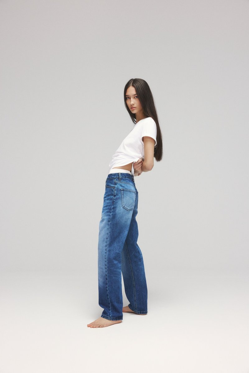 substantial-times-rebellion-der-revoluzzer-ecoalf-denim-03 Seitliche Ansicht eines Models in weißem T-Shirt und weiter Jeans.