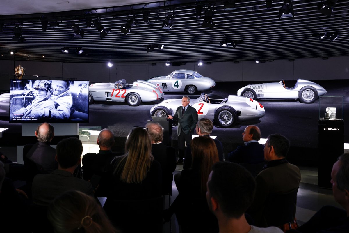 substantial-times-chopard-mille-miglia-speed-silver-02 Vortrag von Karl-Friedrich Scheufele vor Publikum und Presse im Mercedes-Benz Museum, im Hintergrund mehrere silberne historische Rennwagen