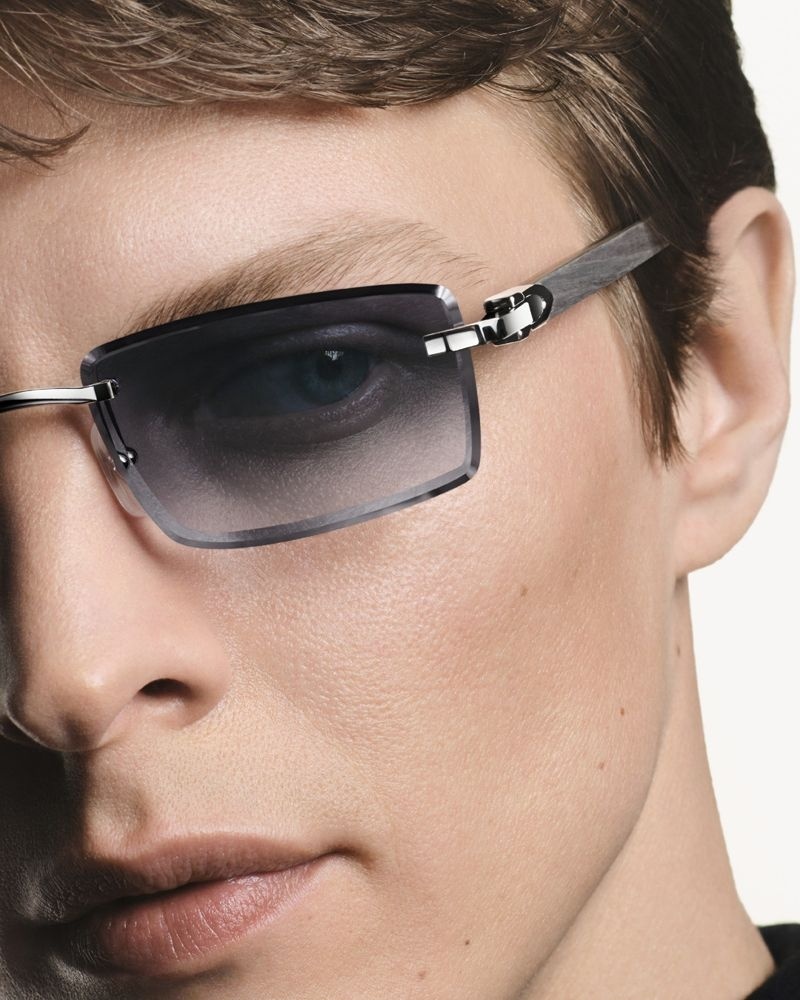 Mann, Gesicht im Anschnitt, trägt randlose rechteckige Sonnenbrille mit Metallbügeln