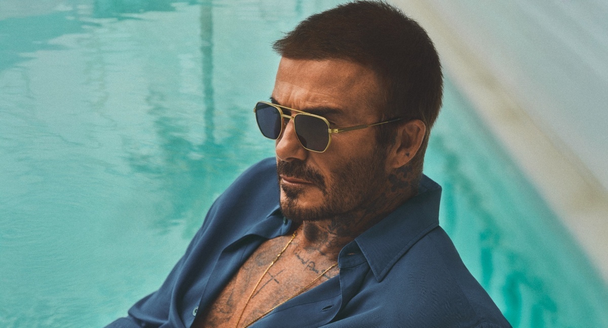 Mann mit Sonnenbrille, David Beckham, sitzt am Pool einer modernen Villa