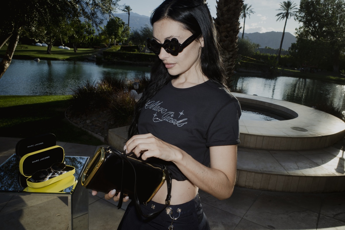 Marta Pozzan steht am Pool und trägt eine schwarze Sonnenbrille in Blütenform