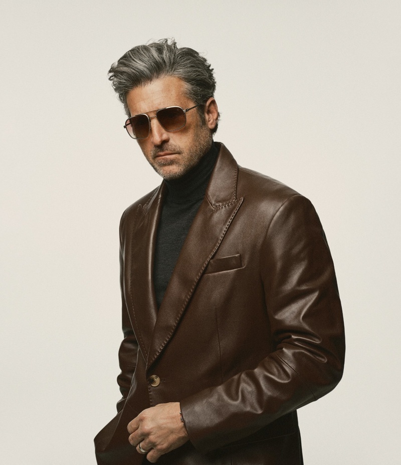 Mann mit grauem Haar, der Schauspieler Patrick Dempsey, trägt braune Sonnenbrille, schwarzen Rollkragenpullover und braunes Lederjackett