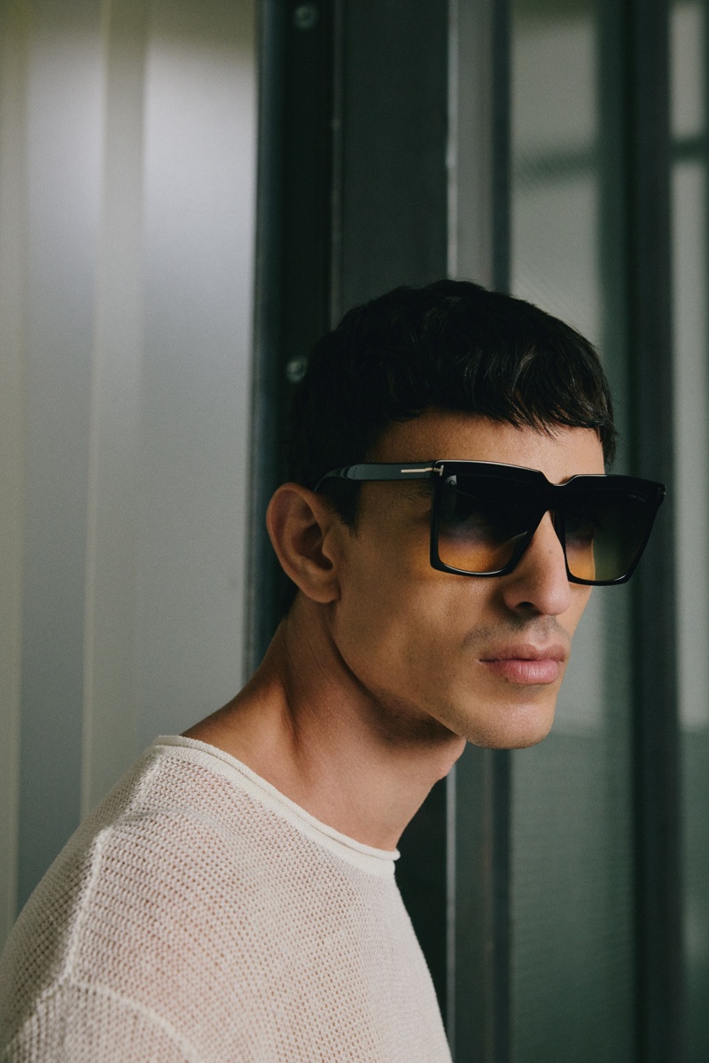 Männliches Model mit großer schwarzer eckiger Sonnenbrille mit gelb-grauem Farbverlauf vor neutralem Hintergrund