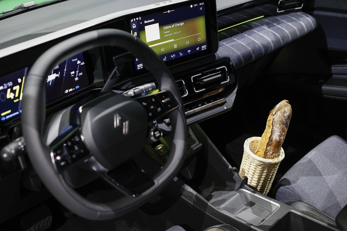 Innenraum eines Renault Elektroautos mit Lenkrad und Display, in der Mittelkonsole ein geflochtener Korb mit einem Baguette