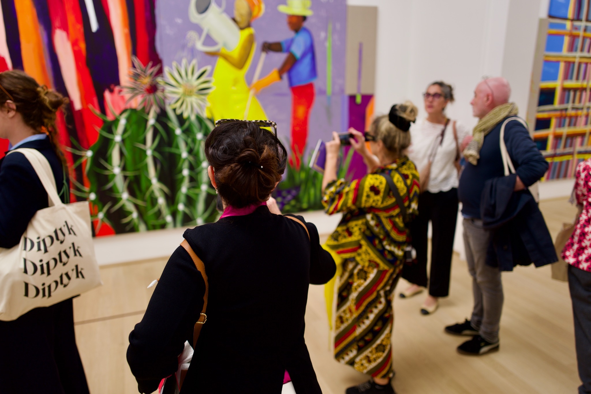 substantial-times-biennale-arte-2026-ausstellung-besucher Besucherinnen und Besucher betrachten farbintensive Kunstwerke in einem Ausstellungspavillon der Biennale in Venedig