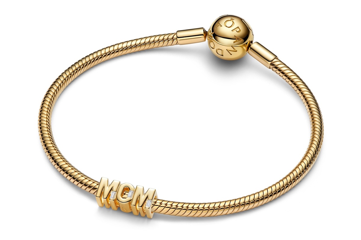 14 Karat vergoldetes Gliederarmband von Pandora mit MOM Charm Anhänger und zirkoniaähnlichen Steinen auf hellem Hintergrund