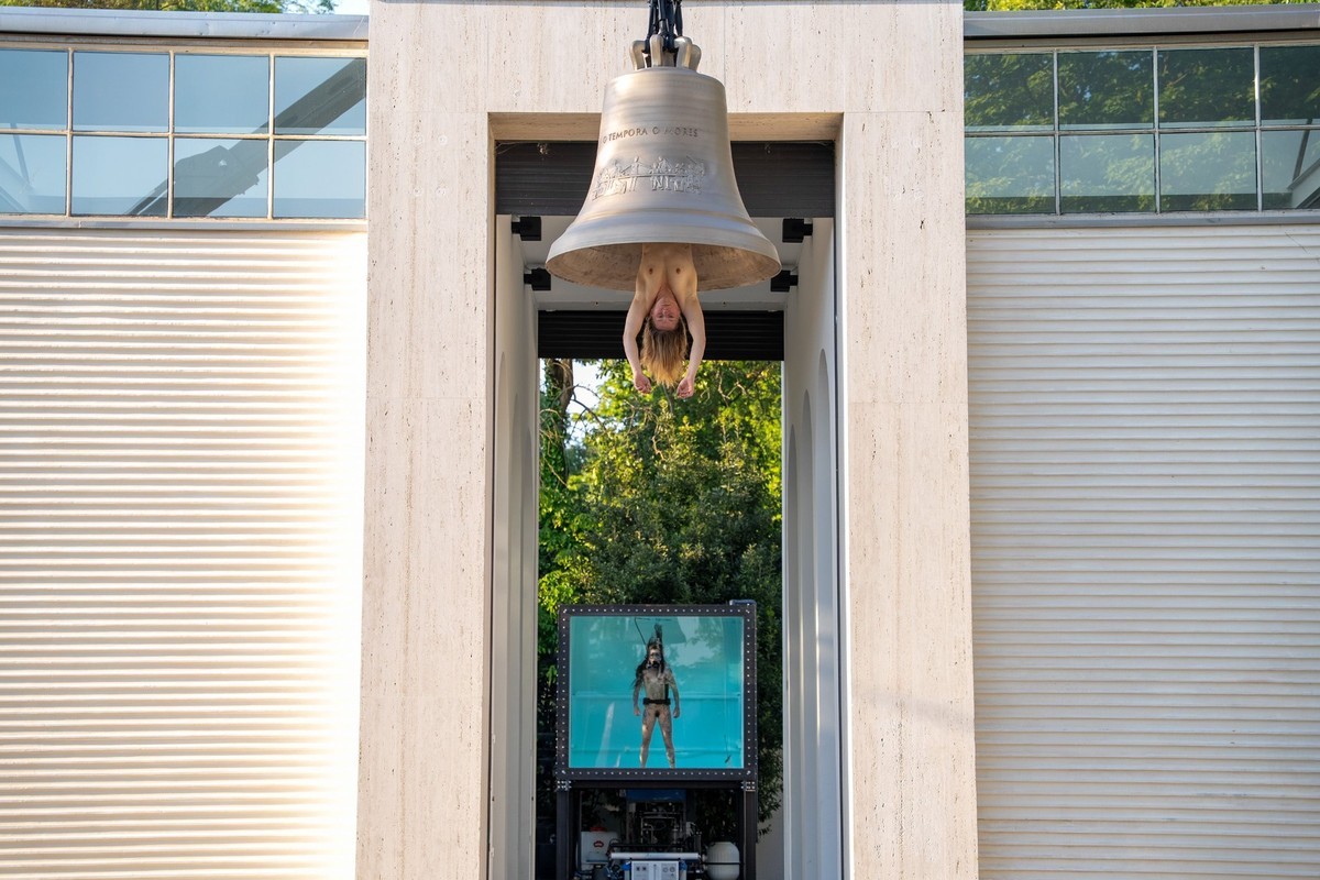Florentina Holzinger hängt als menschlicher Klöppel in einer Glocke am Eingang des österreichischen Pavillons der Biennale Venedig