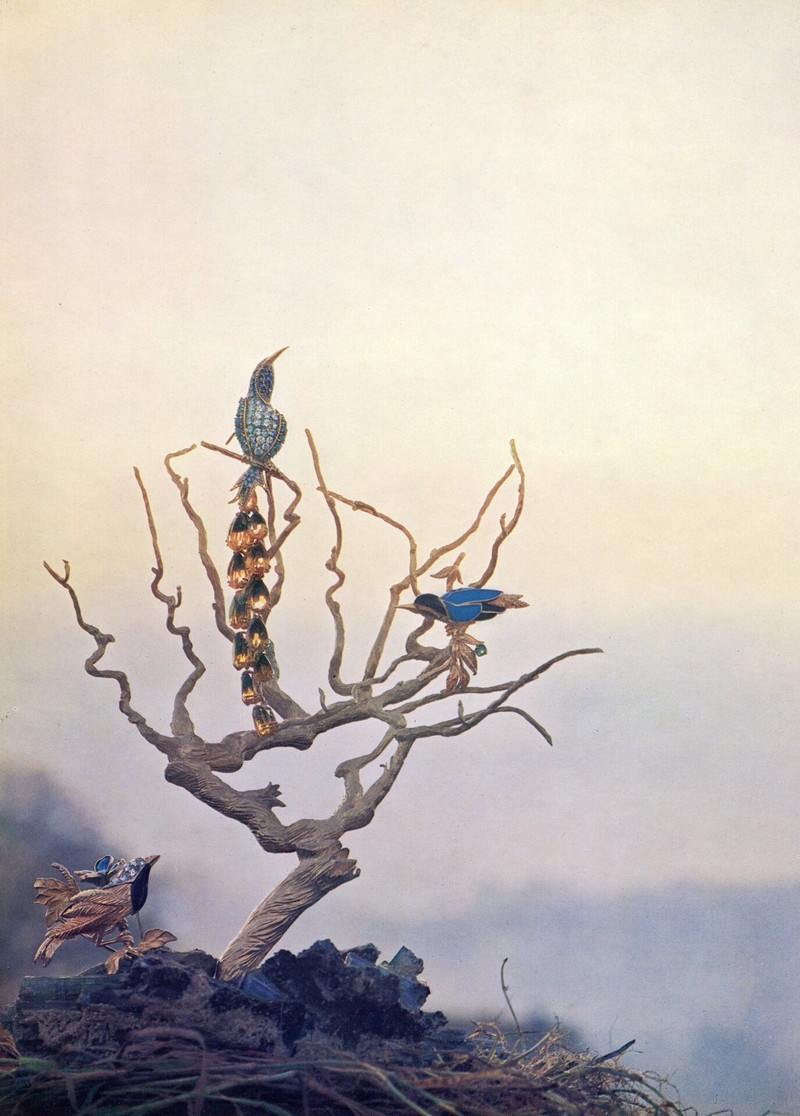 substantial-times-1964-rene-kern-brosche-vogel Schmuckkomposition von René Kern aus dem Jahr 1964 mit mehreren farbenfrohen Vogelbroschen an einem verzweigten Baum