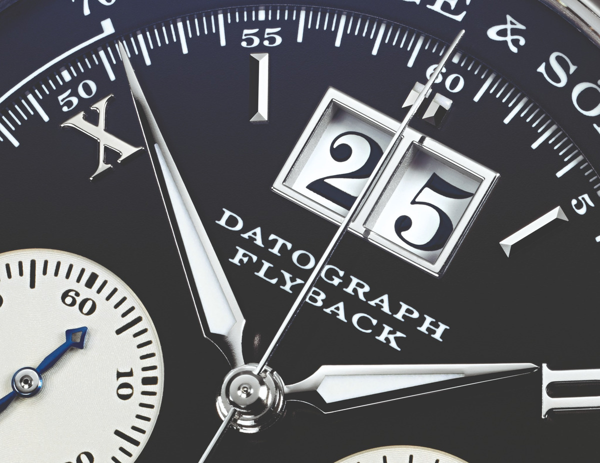 substantial-times-a-lange-soehne-datograph-1999 A. Lange & Söhne Datograph mit hellem Zifferblatt, arabischen Ziffern, gebläuten Zeigern und schwarzem Lederarmband vor schwarzem Hintergrund